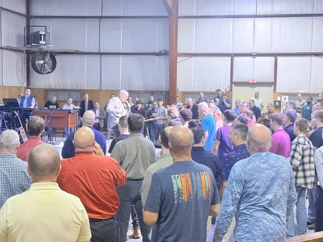 Congregation stands around the platform as a speaker ministers.