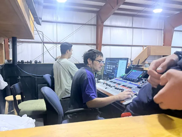 Production volunteers operating audio and video equipment during service.