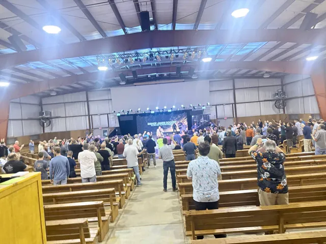 Center-aisle view of the full hall during worship.